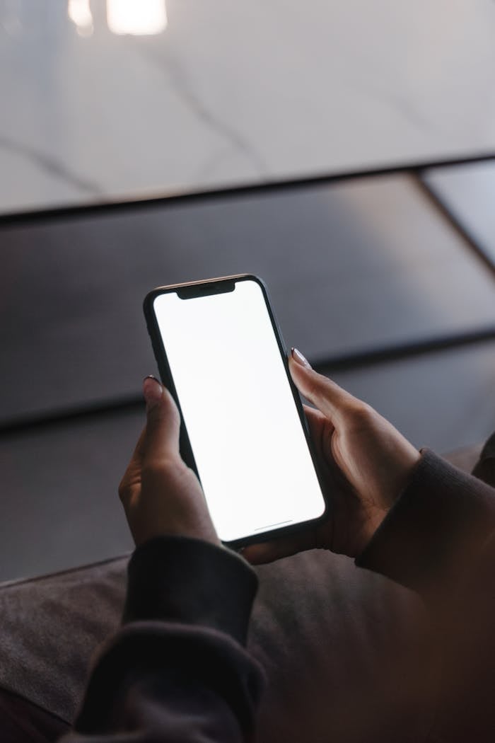 Close-up of hands holding a smartphone with a blank screen, perfect for mockup purposes.